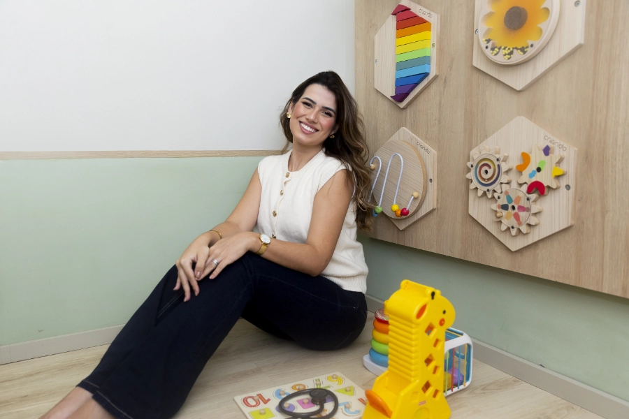 Dra. Caroline Ribeiro examinando um bebê sorridente
